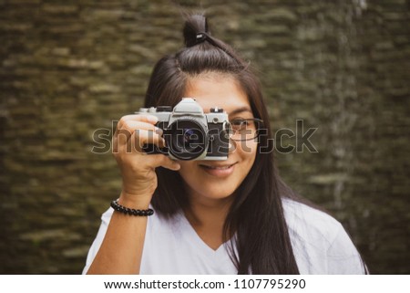 Asian woman act to take photo with retro camera