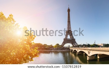 small paris street with view on the famous paris eifel tower on a sunny day with some sunshine Royalty-Free Stock Photo #1107812819