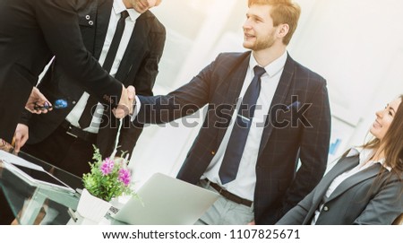handshake of business partners after signing the contract in the