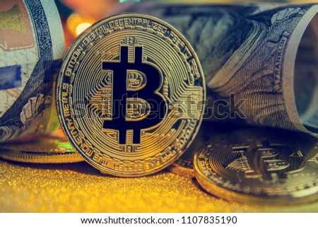 bitcoin of the black background,  on Golden nugget gold background. Finance concept; toned