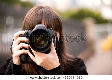 Woman taking a photo in the city during the day with bokeh background