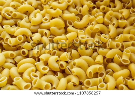 Uncooked italian pasta background. Elbow Macaroni with a smooth surface