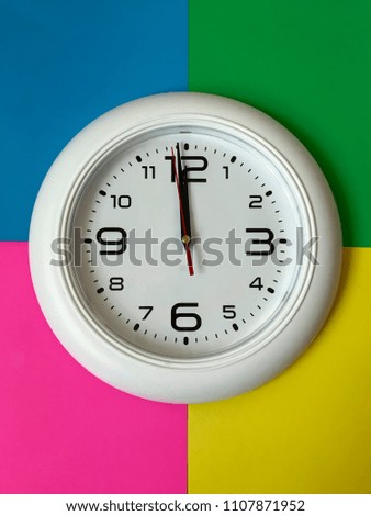 White wall clock on a multi-colored background