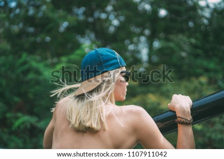 young blonde white caucasian female in baseball hat riding in the back of the car thru jungle rainforest. Travel lifestyle background. 