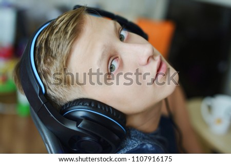 teen boy wearing headphone at home playing games