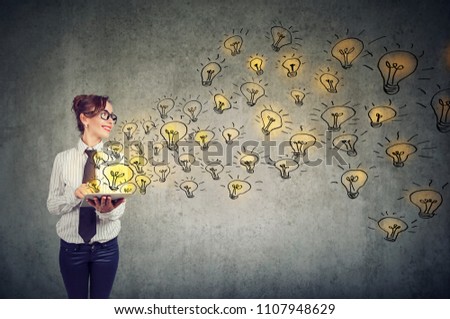 Side view of young business woman holding tablet computer with brilliant ideas  Royalty-Free Stock Photo #1107948629