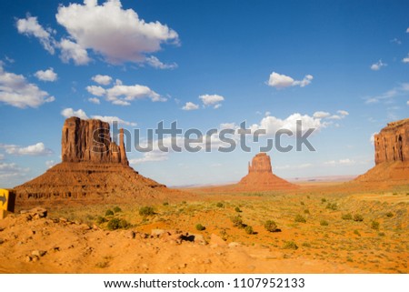 Monument Valley under a cloudy blue sky