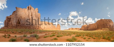 Monument Valley under a cloudy blue sky