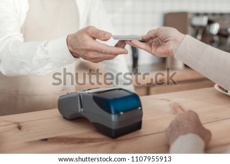 Paying the check. Focused photo on electronic device that lying on the table and being ready for receiving payment