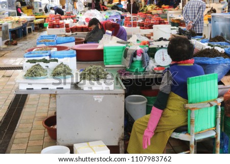 Ajumma vendor selling seafoods at Dongmun Traditional Market In Jeju Island,South Korea.This market is also filled with agricultural products ,black pork  and local souvenirs. Royalty-Free Stock Photo #1107983762
