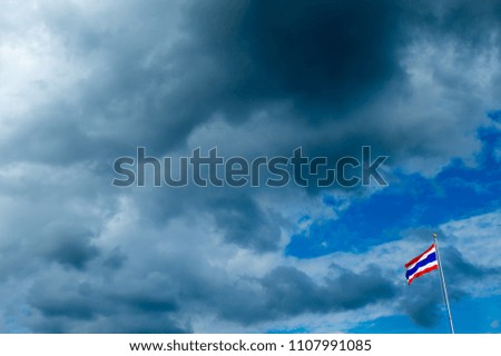 Thailand flag poles and a rain cloud