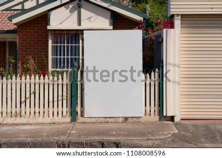 Blank real estate sign outside an suburban residential property.