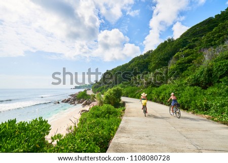 women cycling around the beautiful beaches, La Digue Island, Seychelles              Royalty-Free Stock Photo #1108080728