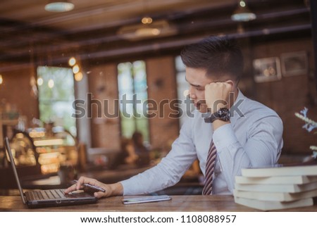 Sad businessman sitting at the table with many folders in office