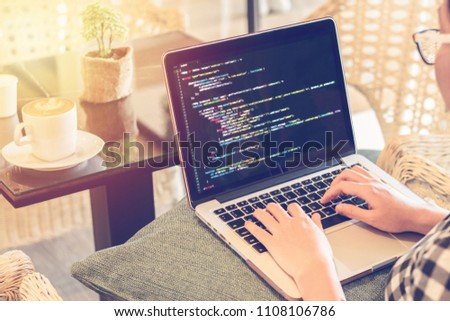 A programmer typing source codes in a coffee shop with a relaxing working environment. Studying, Working, Technology, Freelance Work, Software and Web Development Concept. Royalty-Free Stock Photo #1108106786