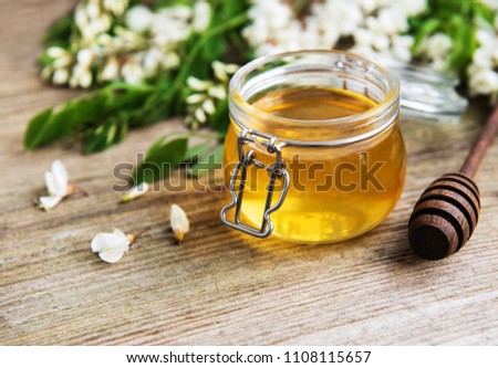 Honey with acacia blossoms on a wooden background