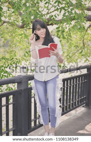 Education Concepts. Asian women reading books in the park. Beautiful women are relaxing in the park.