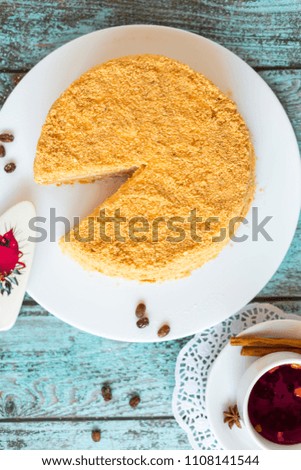 Honey cake on white plate on wooden table. Picture for a menu or a confectionery catalog. 