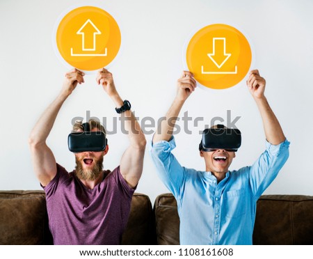 Two men with VR goggles holding technology signs