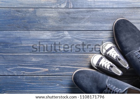 Big and small shoes on wooden background. Father's day celebration Royalty-Free Stock Photo #1108171796