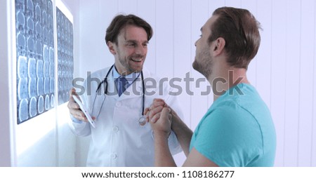 Happy Doctor Man Having Positive Dialogue with Young Patient About Brain Mri Results in Hospital Cabinet or Healthcare Centre Room