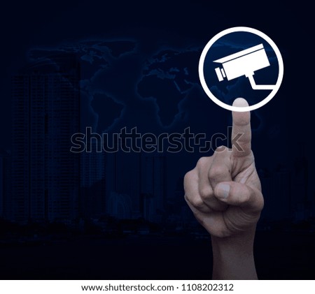Hand pressing cctv camera icon over world map and modern city tower, Business security concept, Elements of this image furnished by NASA