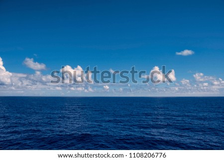 white clouds in late afternoon over blue ocean