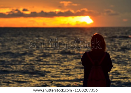 silhouette of sad women are looking at the sunset in  lonely time