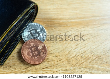 Bitcoin digital currency instead real money, bit-coin with leather wallet or purse on wooden working table, virtual cryptocurrency money business concept idea.
