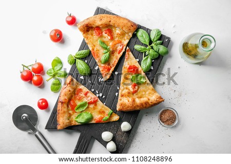 Composition with slices of delicious pizza Margherita on light background