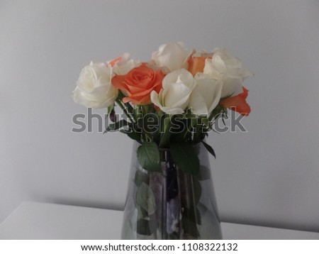 Bouquet of orange and white roses in a glass vase