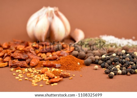 Mixture of spices and garlic stock images. Hot peppers and pepper images. Mixture of spices images. Spice mix on a brown background. Aromatic spice collection