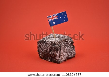 Lamington stock images. Lamington on a red background. Australian sweet delicacy. Important day. Lamington Day background. Australian cake with flag