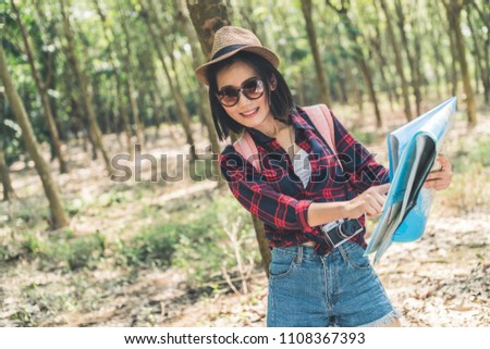 beautiful travel asian woman enjoy walking and take photo with vintage camera in camping forest background with joyful and happiness