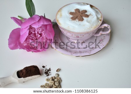A cup of coffee and peonies on a white background.
