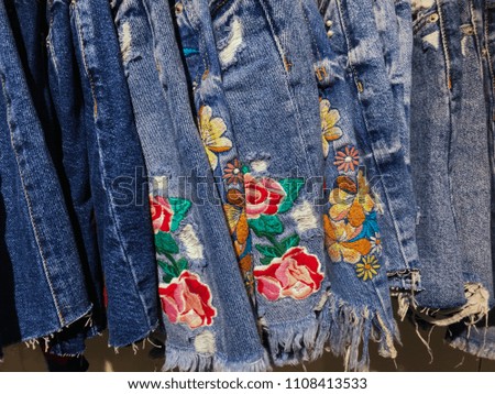 Set of embroidered flowers jeans as a background close-up.
