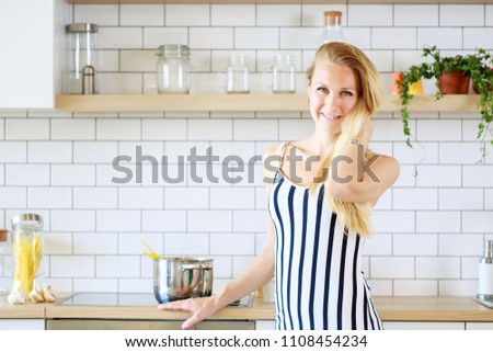 Picture of beautiful woman in long striped dress in kitchen