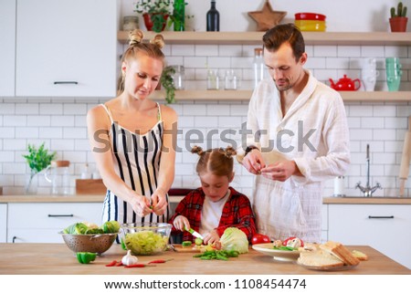 Picture of parents with daughter cooking food in kitchen