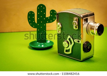 minimalistic holiday background with an old camera and a toy cactus