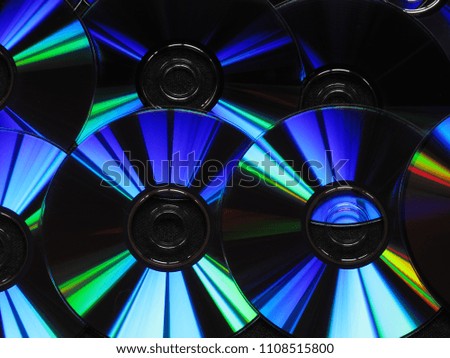 Artistic futuristic background from CD / DVD discs in blue, red and green tones on a black background.