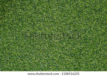 Artificial grass from football field Use as a beautiful green background. closeup, outdoor,