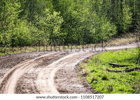 empty gravel road with tracks of mud in the countryside in summer heat perspective in forest