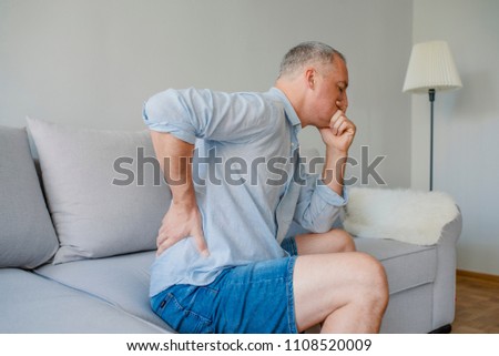 Back Pain. Closeup Of mature man Having Spinal Or Kidney Pain, Backache. Male Suffering From Painful Feeling, Muscle Or Nerve Pain, Holding Hands On Body. Health Issue Concept. High Resolution