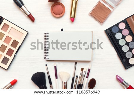 Make up or visage background. Blank page notepad and different cosmetic accessories in the holder with copy space.