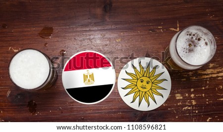 Egypt - Uruguay Coasters at the Bar with Pints. Watching football together concept.