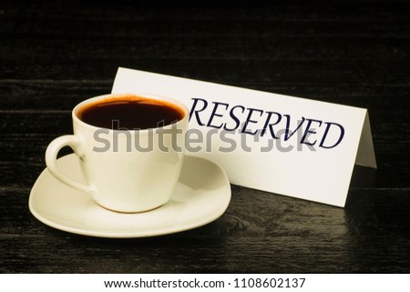 A cup of coffee on a background of plates with the word booking on black boards