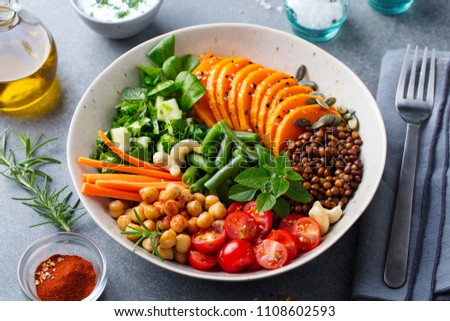Healthy vegetarian salad. Buddha bowl. Lentil. chickpea, carrot, pumpkin, tomatoes, cucumber, lettuce. Close up. Royalty-Free Stock Photo #1108602593