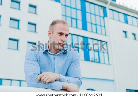 Businessman near a building pondering a business plan