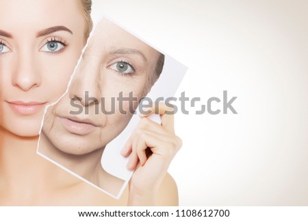 closeup portrait of young woman face holding portrait with old wrinkled face Royalty-Free Stock Photo #1108612700