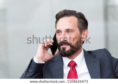 Close up portrait of confident businessman dressed in suit and eyeglasses talking on mobile phone isolated over gray background. business and technology concept - serious businessman with smartphone